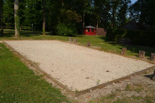 a large sandbox in the grass with a red house in the background at Le Village de la Champagne - Slowmoov in Bar-sur-Aube
