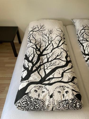 a bed with a picture of two owls on it at B&B Stald Saga in Herning