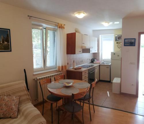 uma cozinha com mesa e cadeiras num quarto em Apartma Brnistra Ginestra em Koper