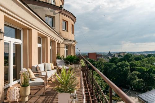 a balcony with couches and plants on a building at Penthouse Panorama - LoftAffair in Kraków