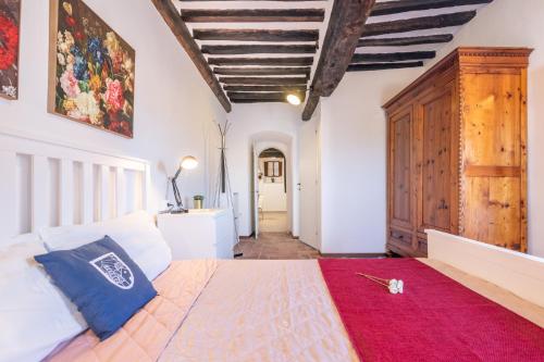een slaapkamer met een groot bed en een rood tapijt bij Fabbrica: Two-wheeler lovers in Peccioli
