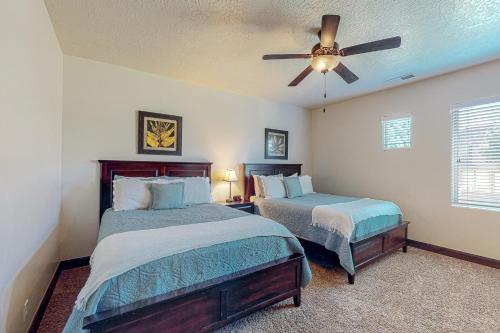 ein Schlafzimmer mit zwei Betten und einem Deckenventilator in der Unterkunft Coral Ridge Retreat in Washington