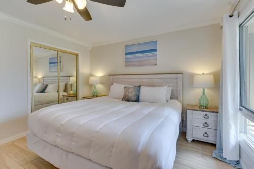 a bedroom with a large white bed and a mirror at Stewart House in the Beautiful SeaScape Resort in Destin