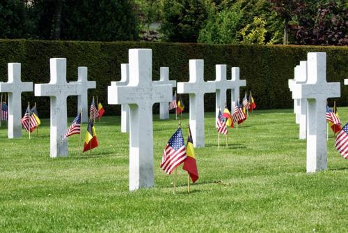 a row of white crosses with flags in the grass at St-Janshof Hotel in Waregem