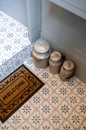a room with three stools on a tile floor with a rug at Boutique apartment Mezrozite in Kuldīga