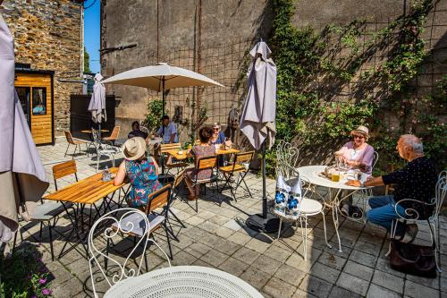 a group of people sitting at tables in a patio at La Jolie Pause in La Gacilly