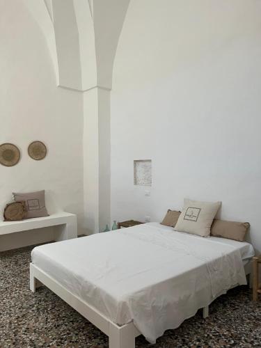 ein weißes Schlafzimmer mit einem weißen Bett in einem Zimmer in der Unterkunft L’Edicola Votiva in Casarano