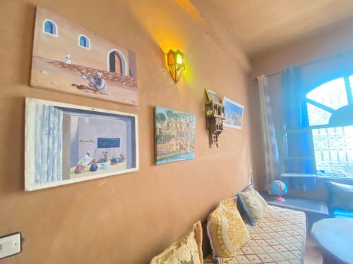 a bedroom with a bed and pictures on the wall at Riad Dar Barbara in Ouarzazate
