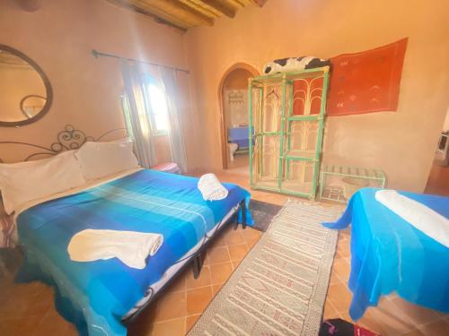 a bedroom with a blue bed and a dresser at Riad Dar Barbara in Ouarzazate
