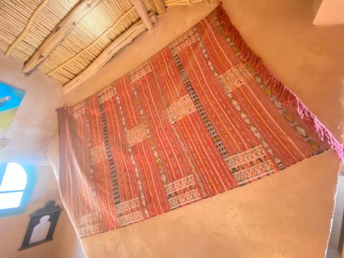 a red rug on the wall of a room at Riad Dar Barbara in Ouarzazate