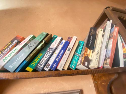 a bunch of books sitting on a shelf at Riad Dar Barbara in Ouarzazate