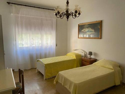 a bedroom with two beds and a chandelier and a window at DodoHouse2 in Amandola
