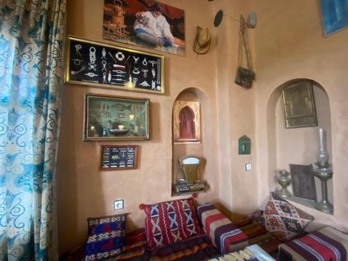 a living room with a couch and pictures on the wall at Riad Dar Barbara in Ouarzazate