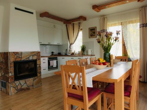 a kitchen and dining room with a table and a fireplace at Wideta in Smerek
