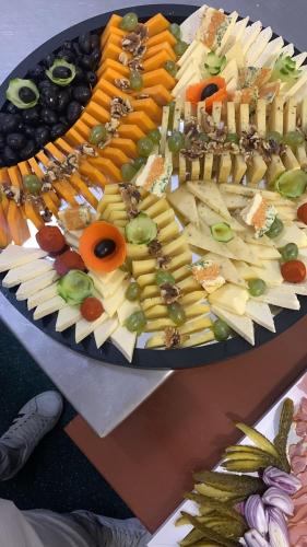 a tray of cheese and vegetables on a table at Pensiunea 7 Tei in Cisnadioara