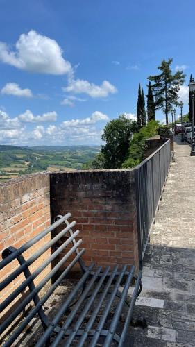 a bench sitting next to a brick wall at Casa di Duccio in Montone