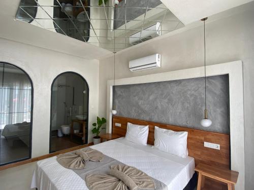 a bedroom with a large white bed with a large window at On Oda Oludeniz in Oludeniz