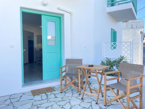 une table et des chaises sur une terrasse avec une porte bleue dans l'établissement Just Live, à Triovasálos