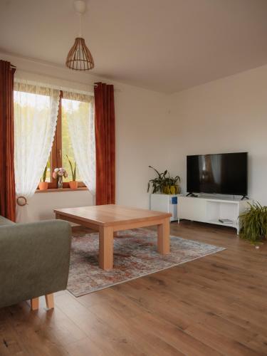 a living room with a coffee table and a tv at Wideta in Smerek