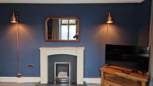 a living room with a fireplace and a tv at Carr Garth in Arnside
