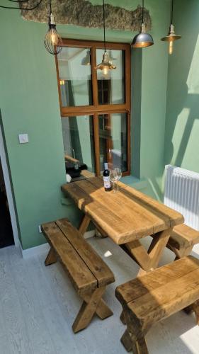 a wooden table and benches in a room with a window at Carr Garth in Arnside