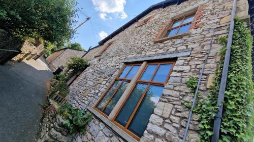 a stone building with windows and ivy at Carr Garth in Arnside
