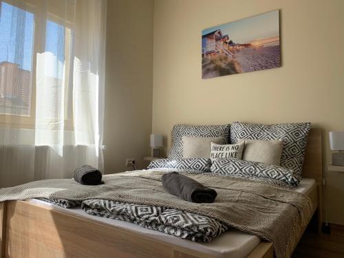 una camera da letto con letto, cuscini e finestra di Mayer Vendégház a Miskolc