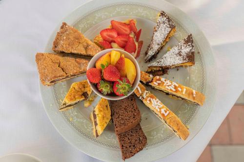 un piatto di dolci con una ciotola di fragole di Agri Divin Amore a San Costanzo