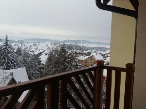 a view of a snowy town from a balcony at Reka in Zlatibor
