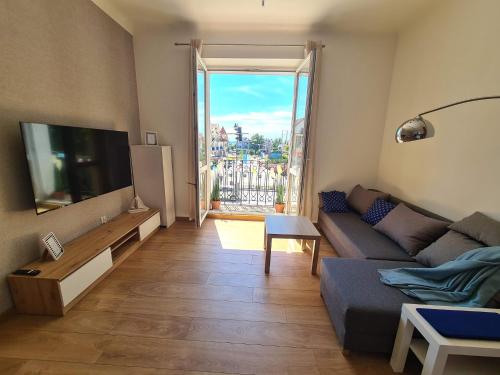 a living room with a couch and a flat screen tv at Apartament Pasaż, 2 Sypialnie i Salon, Centrum in Giżycko