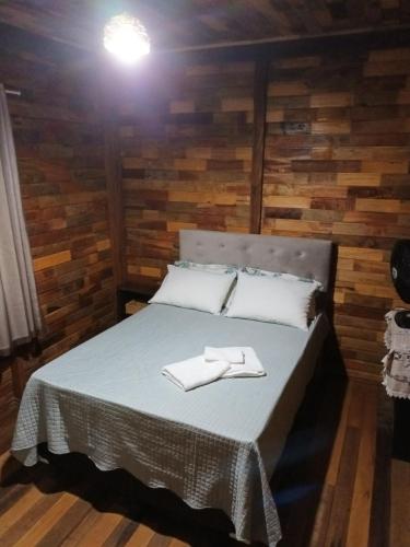 a bedroom with a bed with two towels on it at Nossacasa-de-campo in Blumenau