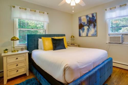 a bedroom with a blue bed and two windows at Traverse City Home with Fire Pit, Patio and Yard! in Traverse City