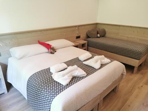two beds with towels on them in a room at Verdi Armonie in Lozzo Cadore