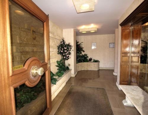 un couloir avec une porte menant à une chambre ornée de plantes dans l'établissement Escale au Val de la Mer, à Antibes