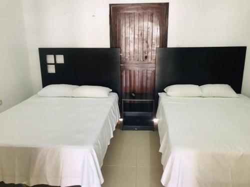 zwei Betten nebeneinander in einem Zimmer in der Unterkunft Casa vacacional Estrella in Cozumel