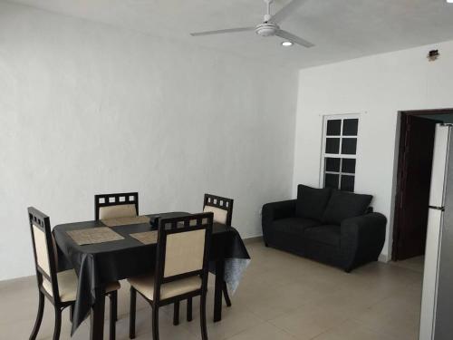 a dining room with a table and chairs and a couch at Casa vacacional Estrella in Cozumel