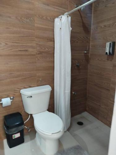 a bathroom with a toilet and a shower curtain at Casa vacacional Estrella in Cozumel
