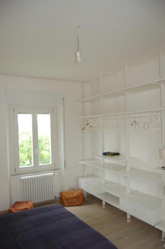 een witte kamer met witte planken en een raam bij Appartamento di charme a Polverigi, Marche in Polverigi