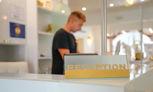 a man in a store with a sign that reads reception at Sirena Suite Deluxe in Peschici