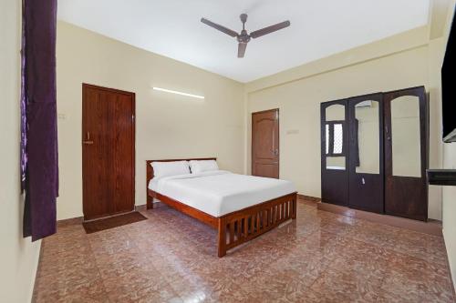 a bedroom with a bed and a ceiling fan at Collection O Senthamizh Residency in Chennai