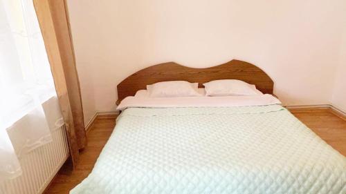 a white bed with two pillows on top of it at Casa Anca in Băile Herculane