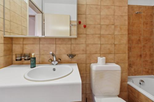 a bathroom with a sink and a toilet and a mirror at Beautiful Boutique Apartment DRAHTZUG8 in Zürich