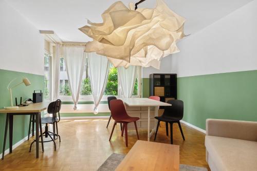 a living room with a table and chairs and a chandelier at Beautiful Boutique Apartment DRAHTZUG8 in Zürich