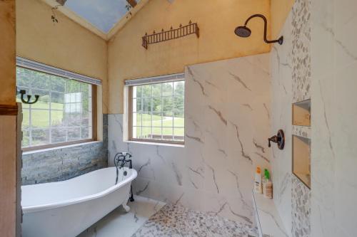 a bathroom with a tub and a window at Classy Home with Hot Tub and Mt Jefferson Views! in West Jefferson