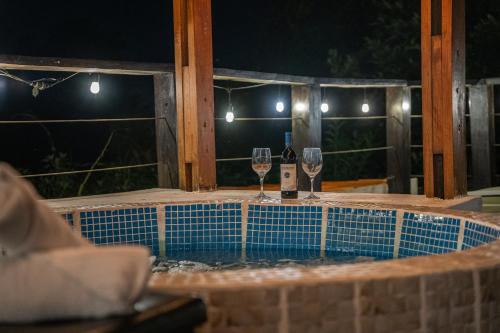 two glasses of wine sitting on a table in front of a window at Vistas del Conde in Heredia