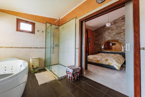 ein Bad mit Badewanne und ein Bett in einem Zimmer in der Unterkunft Villa Hollywood con piscina in Quartu SantʼElena