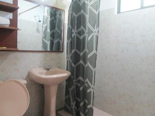 a bathroom with a sink and a toilet and a mirror at CASA MARTIN en Baños de Agua Santa in Baños