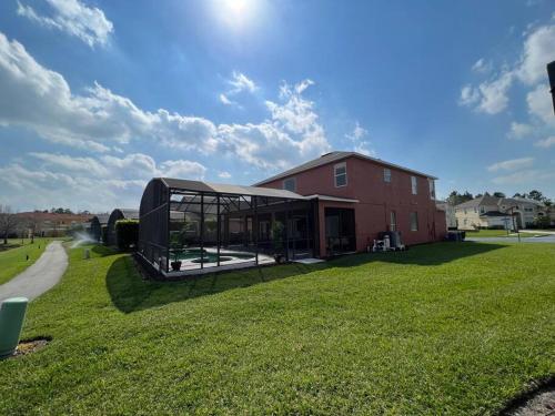 a house with a pavilion in the grass next to a building at Villa Madiera 6 bedroom huge house in Kissimmee