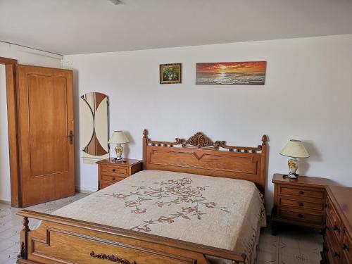a bedroom with a wooden bed and two night stands at Rivabella Economy 2 in Gallipoli