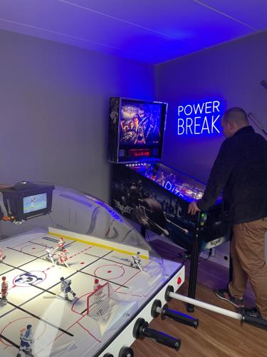 a man playing a video game on a pinball machine at Hotell Nyboholm in Ulricehamn